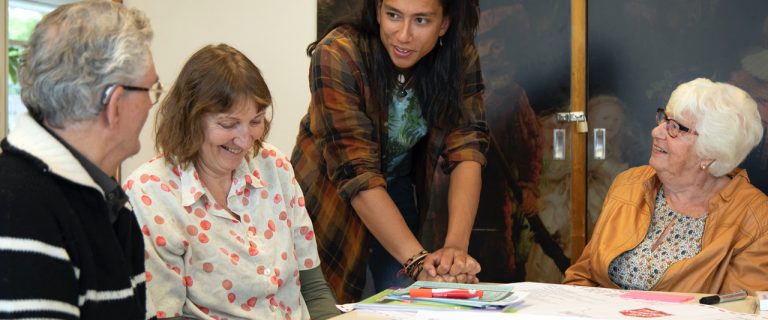 Een medewerker van een Buurtwinkel voor Onderwijs, Onderzoek en Talentontwikkeling (BOOT) in gesprek met ouderen