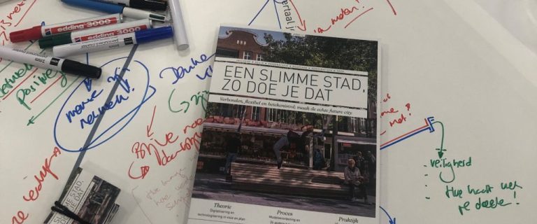 afbeelding van een volgeschreven whiteboard met prominent daarop geplaatst het boek 'Van Slimme Stad naar ecosysteem'.